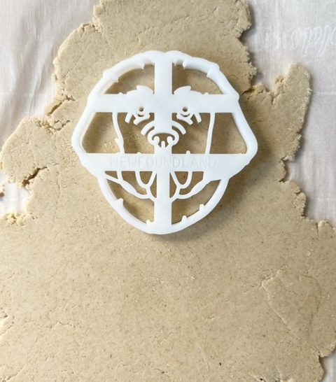 cookie cutter in dog treat oat flour dough