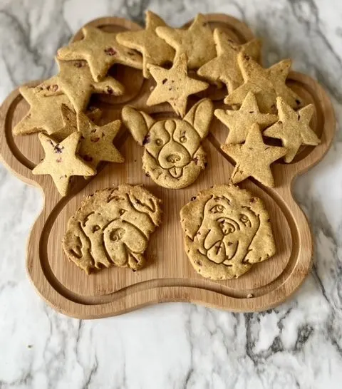 cranberry peanut butter dog treats on a paw shaped serving platter