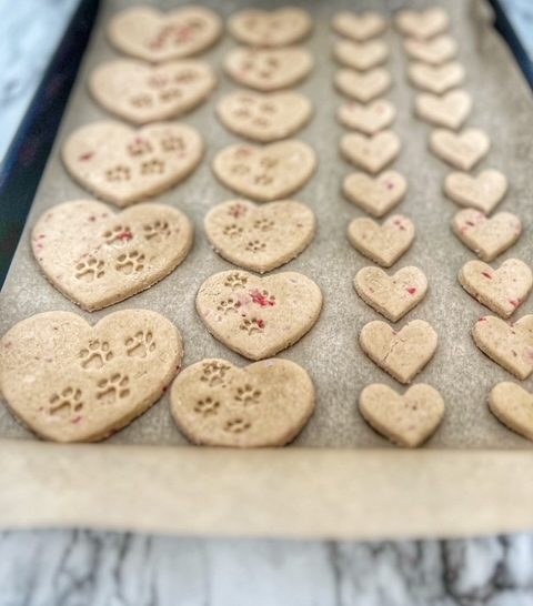 strawberry banana heart-shaped dog treats on a baking sheet